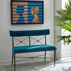 a blue bench sitting in front of a painting on the wall next to a potted plant