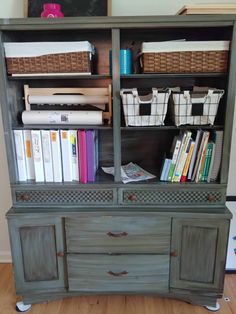 an old china cabinet with baskets and books