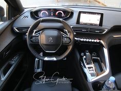 the interior of a modern car with electronic controls and steering wheel, including touchscreens