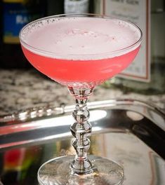 a pink drink sitting on top of a metal tray