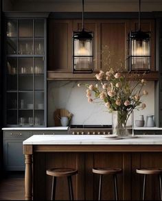 a vase with flowers sitting on top of a kitchen counter next to bar stools