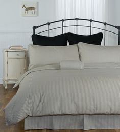 a bed with black and white striped comforter in a bedroom next to a window