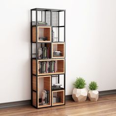 a bookshelf in the corner of a room with two planters on the floor