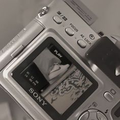 a close up of a person holding a camera in their hand with the screen open