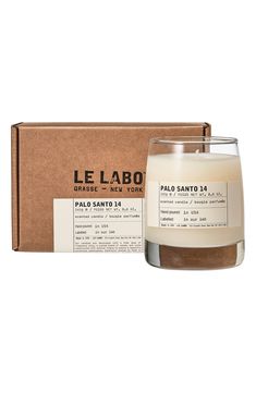 a candle that is sitting in front of a cardboard box with the label on it