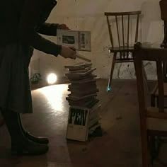 a person standing next to a stack of books