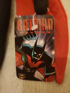 the tag is attached to an orange and black batman costume jacket, which has been worn by someone