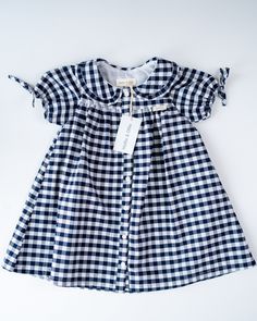 Our gorgeous new Carrie dress is fully lined and 100% cotton. It is available in Blue and White French Floral, Blue and White Gingham and Blue and White Ticking Stripe. The very cute puff sleeve is finished off with a lovely bow and the collar is beautifully edged with a small frill. This is such a versatile little dress to take on holiday, it can so easily be dressed up or down and is perfect for tea parties, going out to lunch or dinner or just playing in the countryside or seaside. And just throw on a cardigan for those cooler days, infact this little dress could carry through to the winter months if you add stockings, wellies and a winter coat. Limited stock in each size and colourway so be sure you don't miss out. Preppy Cotton Plaid Dress, Spring Blue Plaid Cotton Dress, Preppy Plaid Cotton Dress, Cotton Gingham Plaid Dress With Ruffles, Preppy Short Sleeve Dress For Picnic, Fitted Blue Plaid Cotton Dress, Preppy Fitted Plaid Cotton Dress, Fitted Cotton Plaid Dress In Preppy Style, Fitted Plaid Cotton Dress In Preppy Style