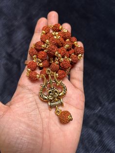 This bold and beautiful Shiva Trident pendant comes on an rudraksh mala gold cap. This is a beautiful way to celebrate your divine masculine energy whatever your gender, and is a beautiful gift for adorning your masculine beloved. See below for more information about this potent, tantric symbol and its meaning. A great gift for yogis and those studying tantra. Brass will oxidize to a more antiqued color over time. If you would like it to be bright and shiny again, just use a little bit of lemon Gold 108 Beads Mala For Meditation, Gold Mala With 108 Beads For Meditation, Gold Mala With 8mm Beads For Meditation, Spiritual Locket Necklace For Diwali, Gold Mala With 108 Beads For Rituals, Brown Spiritual Jewelry For Puja, Brown Necklaces For Puja And Festivals, Festival Brown Necklace For Puja, Handmade Gold Spiritual Mala