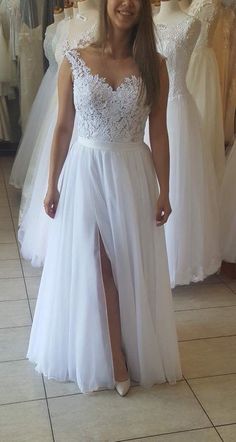 a woman is standing in front of some wedding gowns and posing for the camera