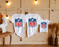 two shirts with the words dad and son on them hanging in front of a wall