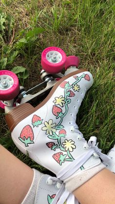 a close up of a person's feet wearing white shoes with pink wheels