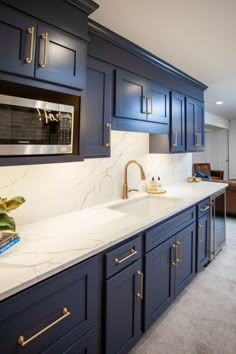 a kitchen with marble counter tops and blue cabinets