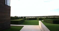 an outdoor area with green grass and hedges