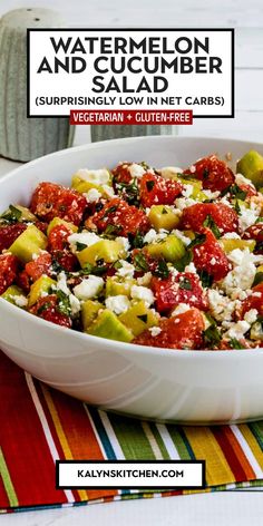 a white bowl filled with lots of food on top of a colorful table cloth next to a jar of watermelon and cucumber salad