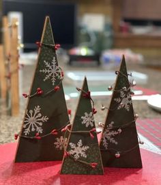 three small christmas trees sitting on top of a table