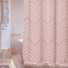 a bathroom with a pink shower curtain next to a toilet