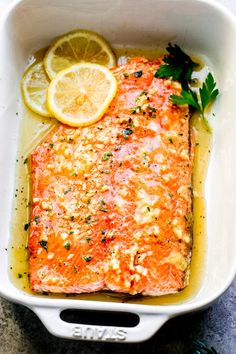 salmon with lemon and parsley in a white casserole dish