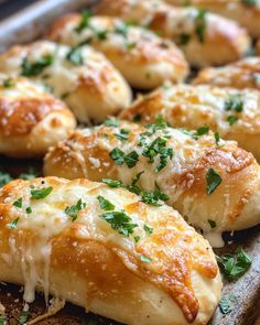 baked bread with cheese and parsley on top sitting in a baking pan, ready to be eaten