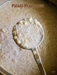 a ladle full of food with rice in it and the spoon is on top