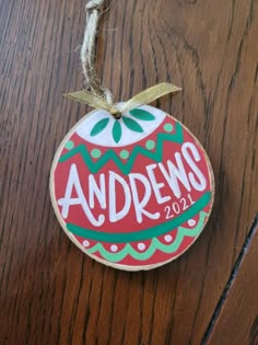 an ornament hanging on a wooden surface with the word andrews written in it