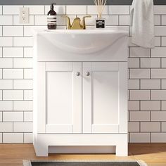 a white bathroom sink sitting under a mirror next to a wall mounted faucet