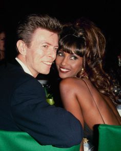 a man and woman sitting next to each other in front of a green table cloth