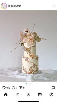 a white and gold wedding cake with flowers on the top is featured in an instagram