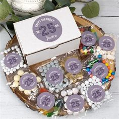 a birthday cake with candy and candies on a wooden platter next to a box