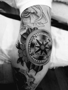 a man with a compass tattoo on his arm and leg is shown in black and white