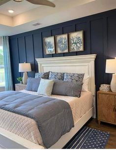 a bedroom with blue walls and white bedding