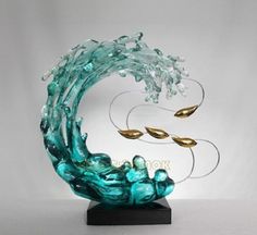 the sculpture is made out of glass and has gold leaves on it