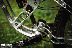 a close up of the front brake on a mountain bike with grass in the background