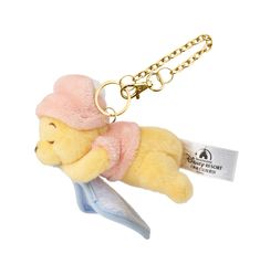 a yellow teddy bear with a pink hat and scarf on it's back is hanging from a gold chain