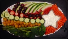 a platter filled with cucumbers, carrots, celery and other vegetables