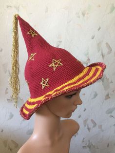 a crocheted hat with gold stars and tassels on the brim