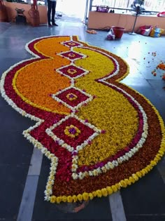 a man standing in front of a large flower arrangement on top of a tiled floor