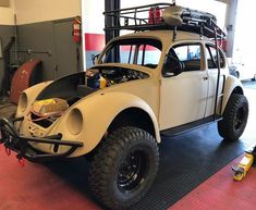 an old vw buggy is parked in a garage