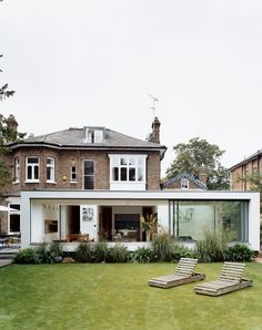 two lawn chairs sitting in front of a house