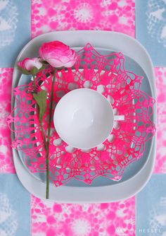 a pink rose sitting on top of a white plate