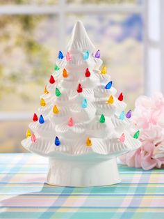 a white ceramic christmas tree with multicolored lights