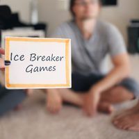 a group of people sitting on the floor with a sign that says ice breaker games