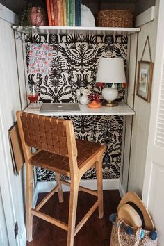 a chair sitting in front of a desk with a lamp on top of it next to a shelf filled with books