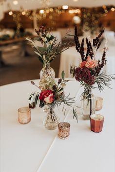 A table at a wedding reception with bud vases that are filled with fall colored flowers and surrounded by votive candles. Designed and made by the florists at Camrose Hill- an outdoor wedding venue and florist located in Stillwater, MN near Minneapolis. Fall Wedding Reception, Rusting Wedding, Wedding Reception Seating, Autumn Wedding Reception, Wedding Reception Flowers, Reception Flowers, Fall Wedding Flowers