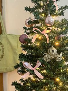 a small christmas tree with ornaments on it and a bag hanging from the wall next to it