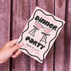 a person holding up a pink dinner party book