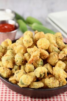 a bowl filled with fried food sitting on top of a red and white checkered table cloth