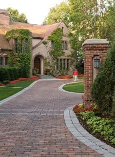 a brick driveway leading to a large house