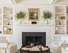 a living room filled with furniture and a fire place under a painting on the wall