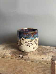 a ceramic cup sitting on top of a wooden box